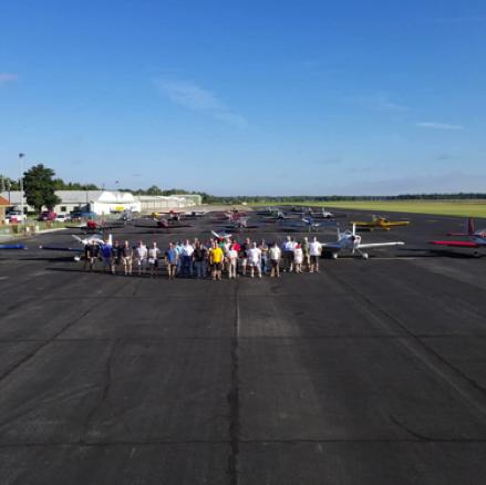 Oct. 6-7, 2018 – A formation of EAA pilots stand before a formation of their aircraft.